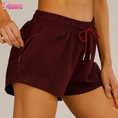 Groothandel Vrouwen Sport Workout Shorts ademend laser gesneden joggen Shorts met warmte-up Zipper Side Pocket Solid Pattern